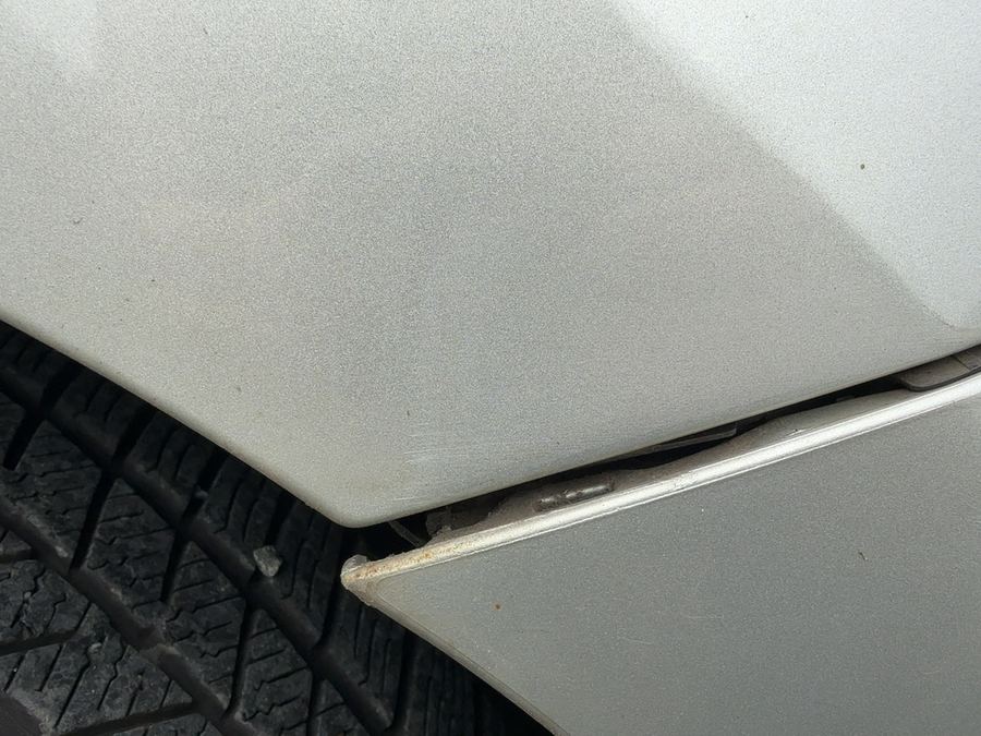 Vordere Ecke eines silbernen Toyota Auris am Radlauf: Der Stoßfänger ist aus seiner Führung am Kotflügel gedrückt, zwischen beiden Teilen klafft ein Spalt